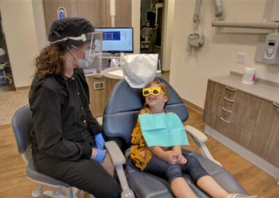Dr. Reyerson is seated with child during dental exam